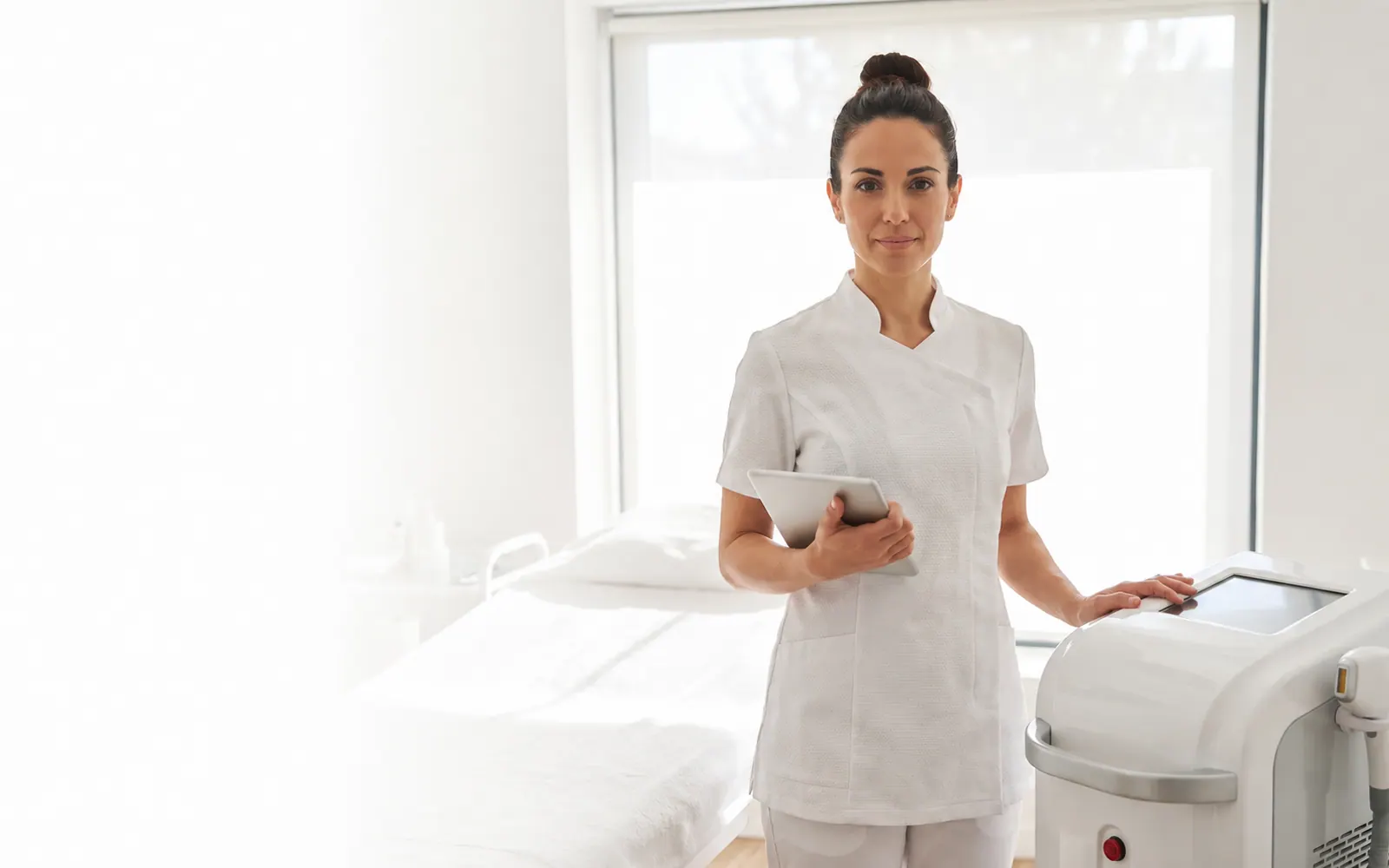 Esteticista junto a su aparatología revisando el coste por minuto de cada sesión en un centro de estética
